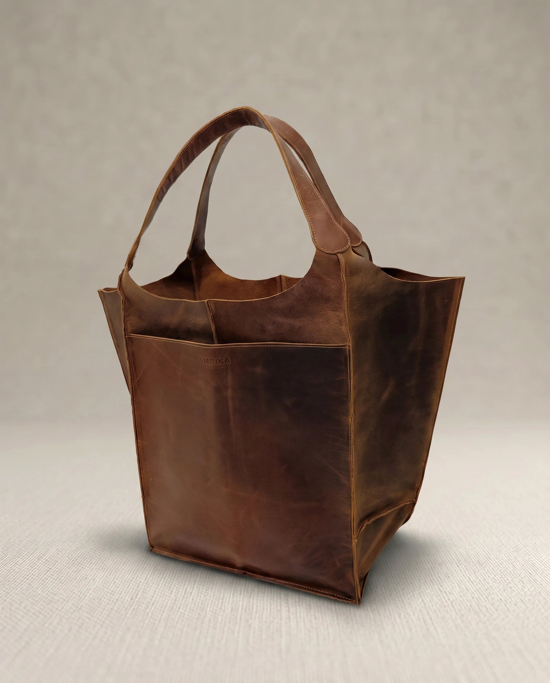 Angled view of The Grand large buffalo leather tote bag by Amrika Leather, crafted from genuine vintage pull-up buffalo leather.