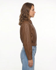 Side view of The Elowen women's brown genuine lambskin cropped leather jacket showcasing its modern cropped fit and elasticized waistband.