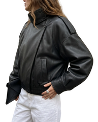 Side view of The Noa women's black genuine lambskin oversized funnel neck leather jacket by Amrika Leather showcasing the relaxed silhouette and modern profile.