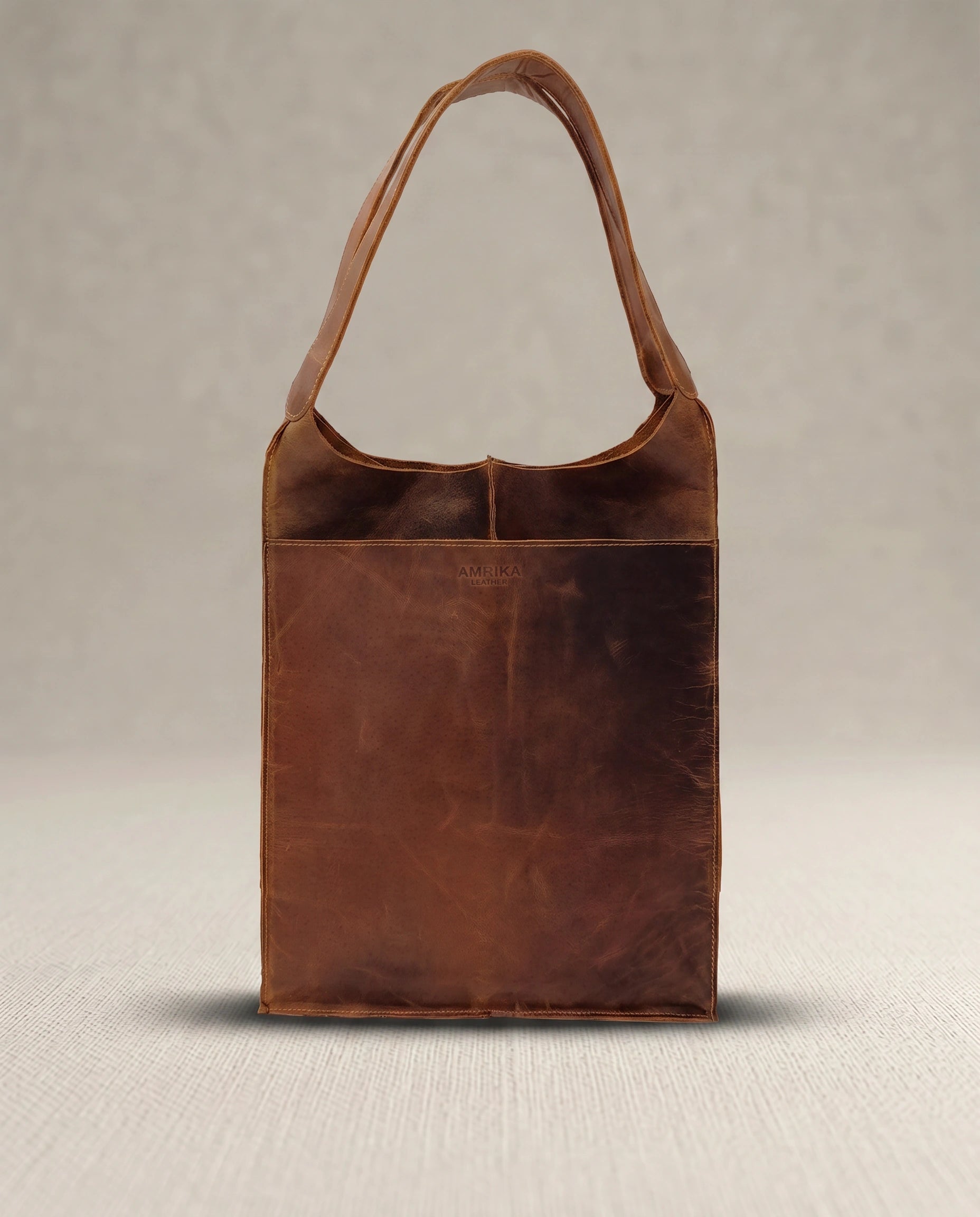 The Grand large buffalo leather tote bag folded for compact storage, crafted from vintage pull-up buffalo leather.
